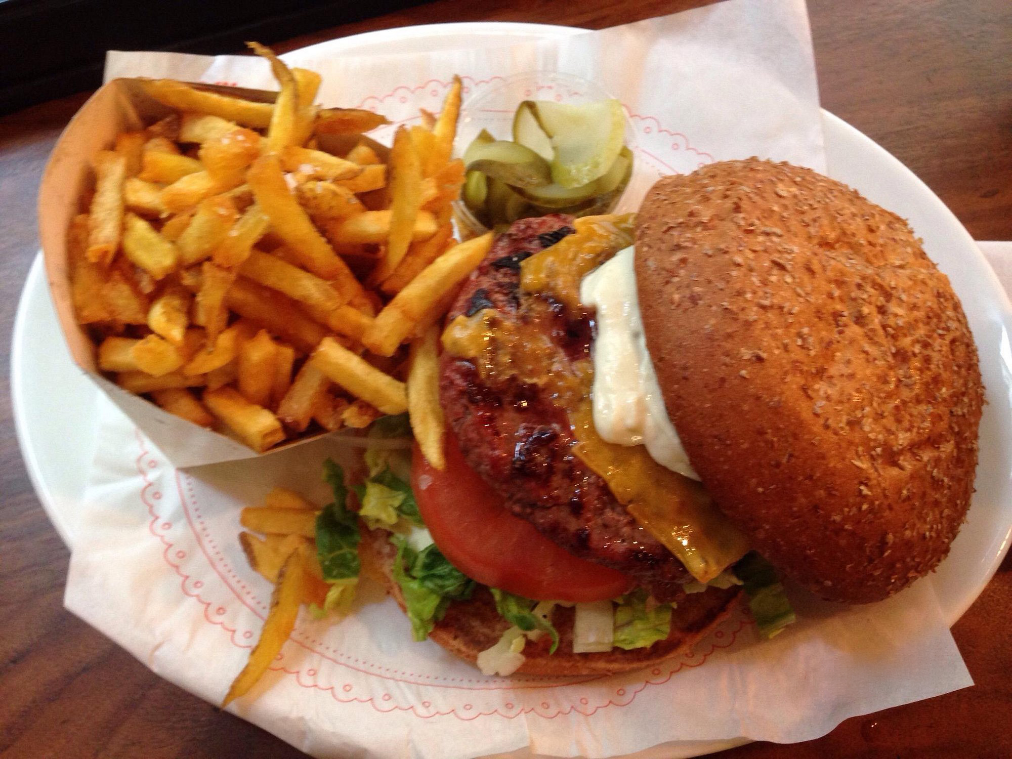 Before: dim phone photo of a burger with fries on a kitchen counter under flat overhead light