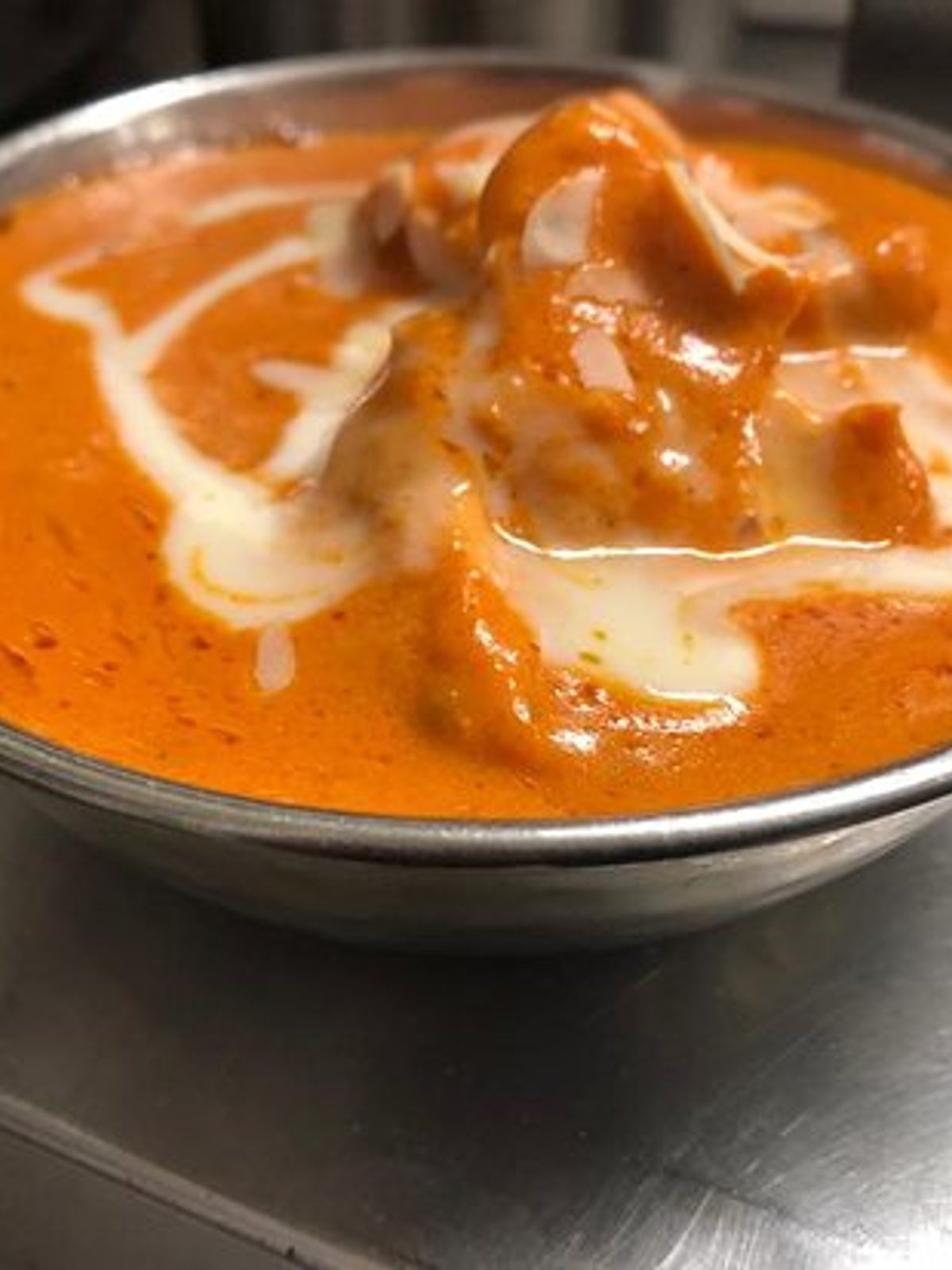 Before: dim phone photo of a butter chicken curry looking like a flat orange puddle in a metal bowl