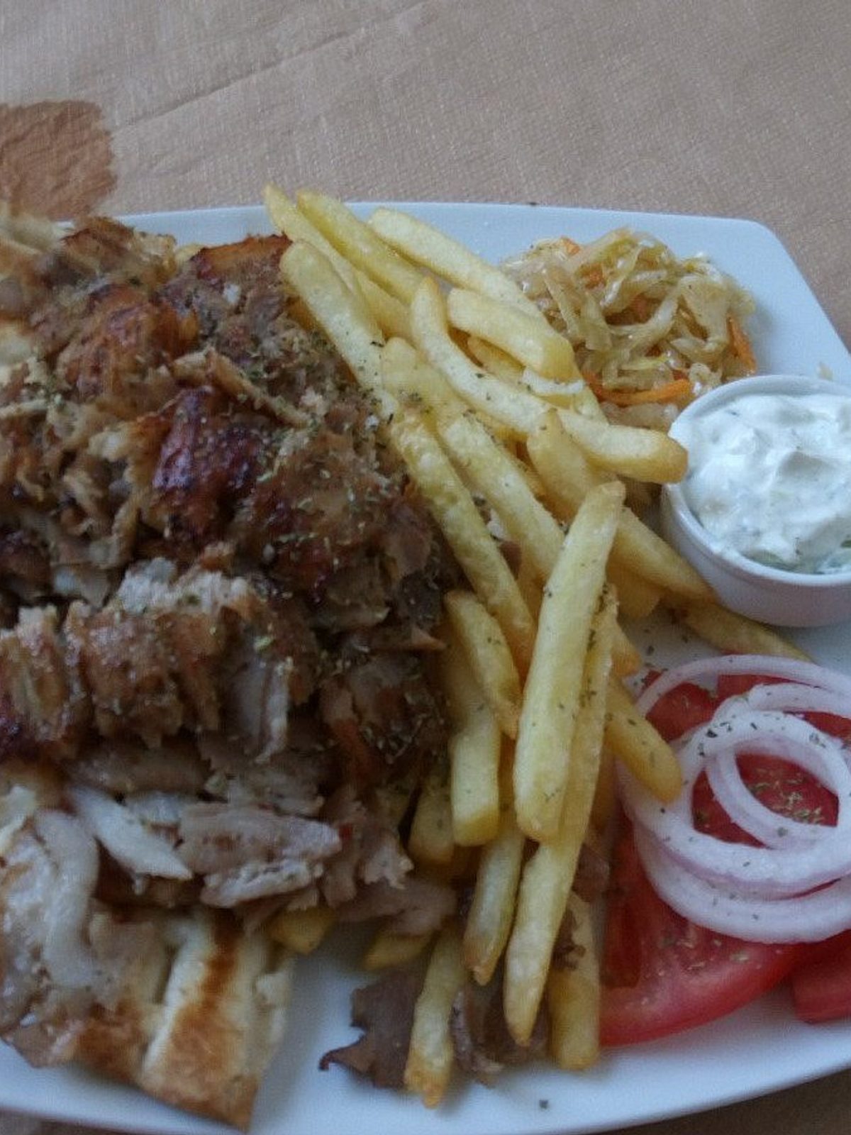Before: dim phone photo of a döner kebab plate with shaved meat, salad and sauce on a metal counter