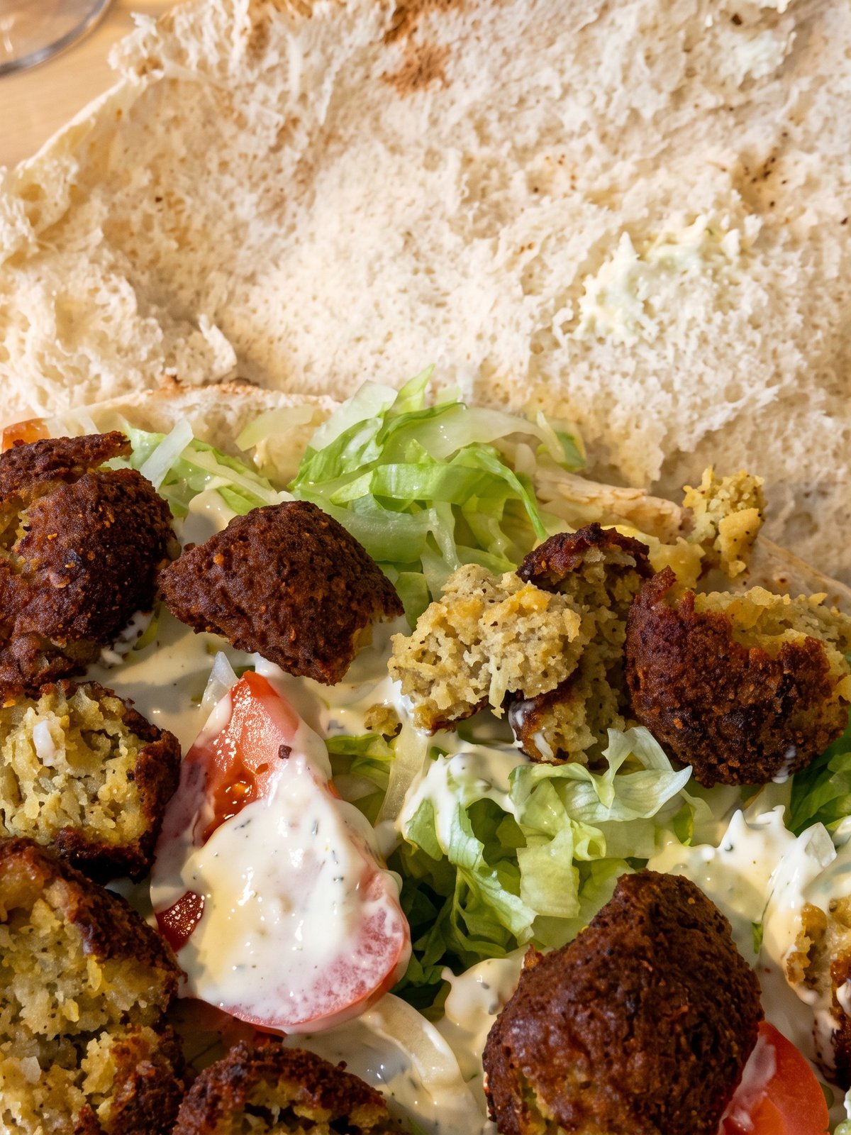 After: studio-lit menu photo of the same falafel plate with crisp golden falafel and fresh salad clearly visible