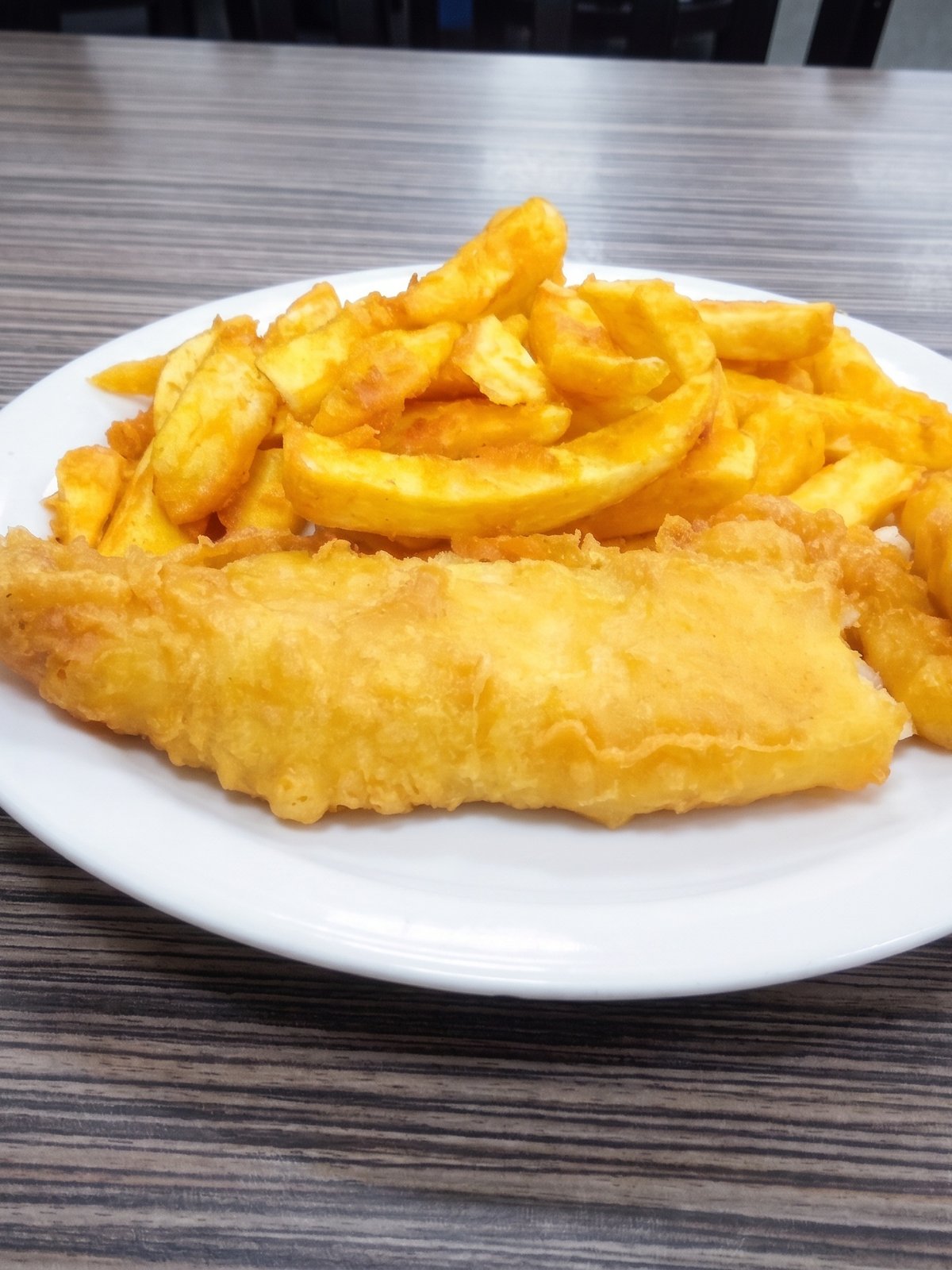 After: studio-lit menu photo of the same fried fish and chips with crisp golden batter and clean presentation