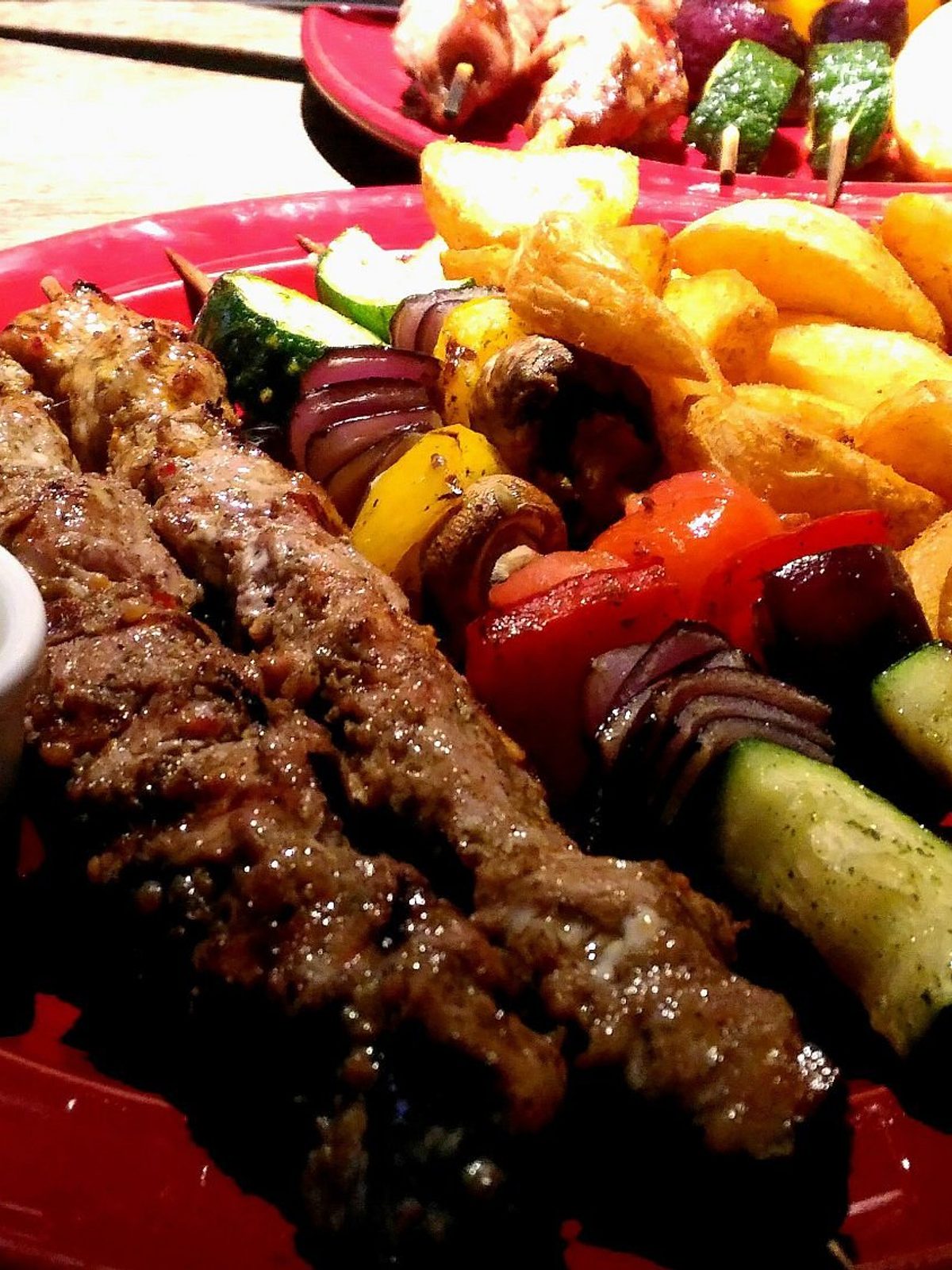 Before: dim phone photo of a mixed grill plate with assorted meats and sides on a kitchen counter