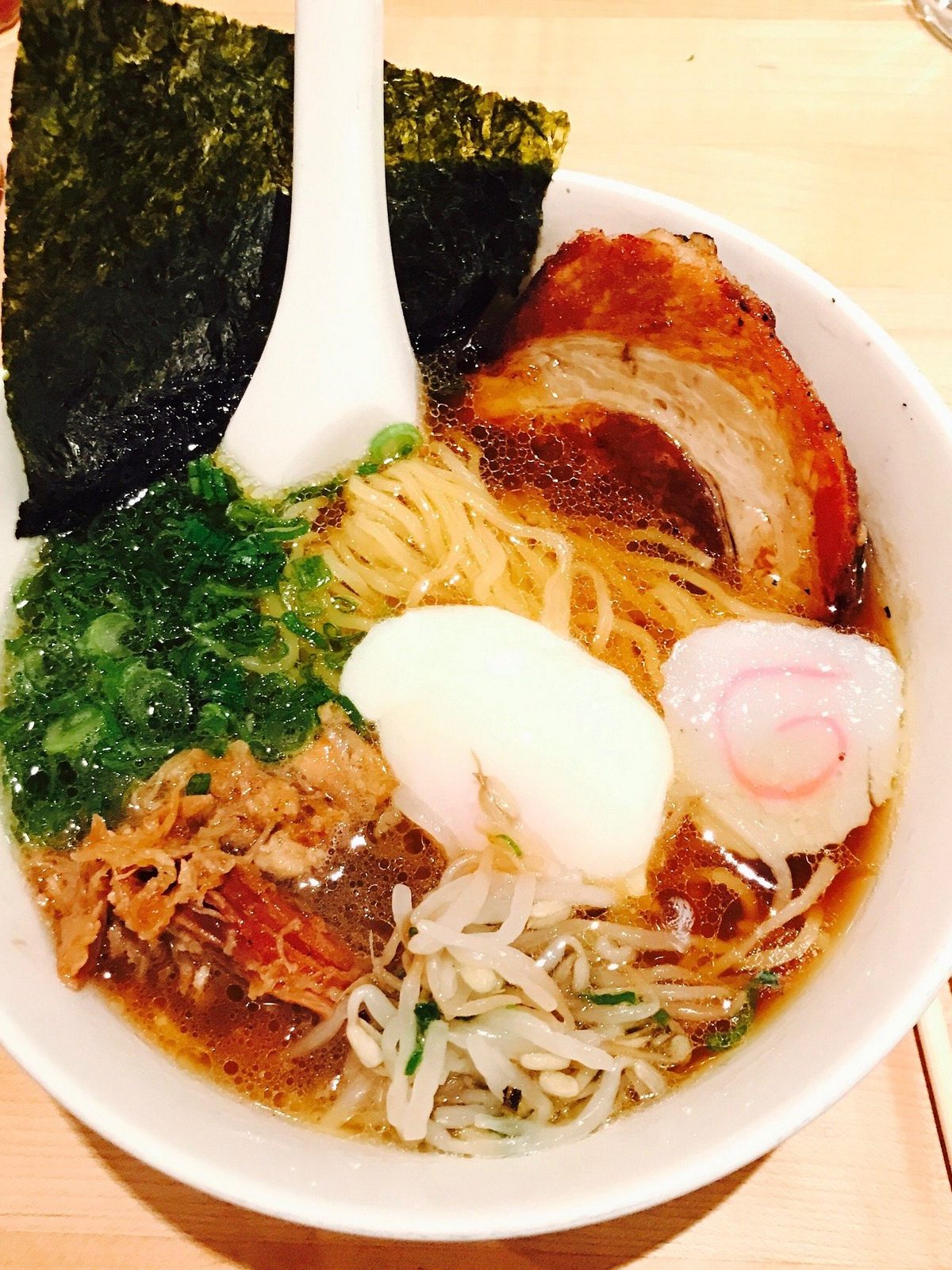 Before: dim phone photo of a bowl of ramen with egg and pork on a kitchen counter